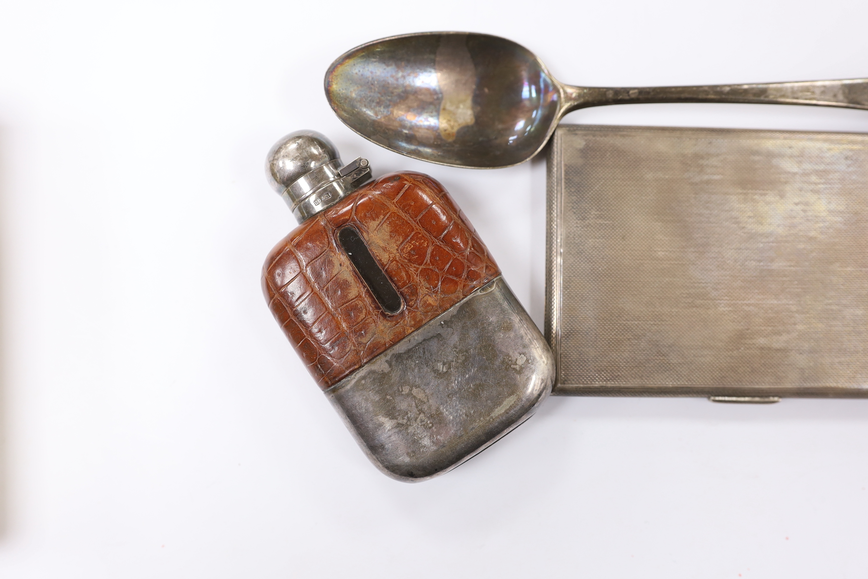 A George VI engine turned silver rectangular cigarette case by Asprey & Co, London, 1942, 12.5cm, together with an 18th century silver base mark table spoon and silver plated and leather mounted hip flask.